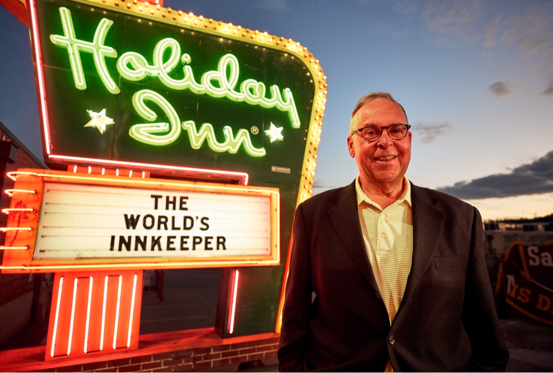Mike Conway, CEO of Winegardner & Hammons, Inc one of the largest franchisees of Holiday Inns, standing beside the sign at the American Sign Museum in Cincinnati
